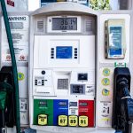 Detalhe de uma bomba de combustível com opções de gasolina e diesel em um posto.