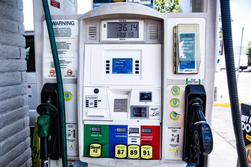 Detalhe de uma bomba de combustível com opções de gasolina e diesel em um posto.