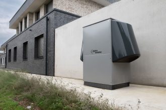 Sistema de bomba de calor instalado na área externa de um edifício contemporâneo.