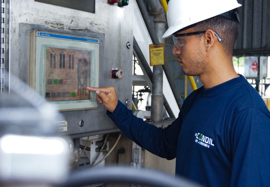 Profissional opera um painel de controle em uma instalação industrial.